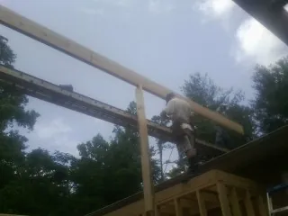 Carpenter setting a ridge beam over a new addition frame — Ice Dam Removal by Roofing Brothers in Dorchester